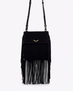 A close-up view of a black handbag with one long strap and gold hardware, including tassels at the ends, and a gold wing design adorned at the top center.