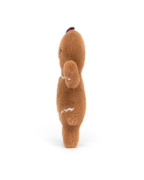 Side view of a brown plush toy shaped like a gingerbread man, featuring white icing-like stitching, a small red detail on top of its head, and one arm raised to its face.