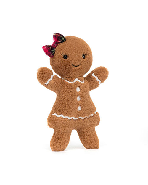 Plush toy shaped like a gingerbread person, featuring brown fabric, white icing-like trim on the arms, neck, and hem of its dress, three white buttons down the front, a red plaid bow on its head, black eyes, and a stitched smile.