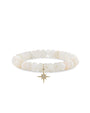 14k gold and pavé diamond starburst charm on 8mm natural African rainbow moonstone bead on white background.