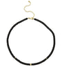 A black beaded choker necklace with gold accents displayed against a white background. The necklace features small black beads throughout, with three equally spaced gold-colored bands adding contrast and elegance. It is secured with a gold-colored lobster claw clasp and has an adjustable chain for varying lengths.