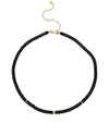 A black beaded choker necklace with gold accents displayed against a white background. The necklace features small black beads throughout, with three equally spaced gold-colored bands adding contrast and elegance. It is secured with a gold-colored lobster claw clasp and has an adjustable chain for varying lengths.