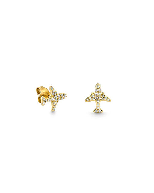 A pair of gold airplane shaped stud earrings encrusted with pave diamonds against a white background.