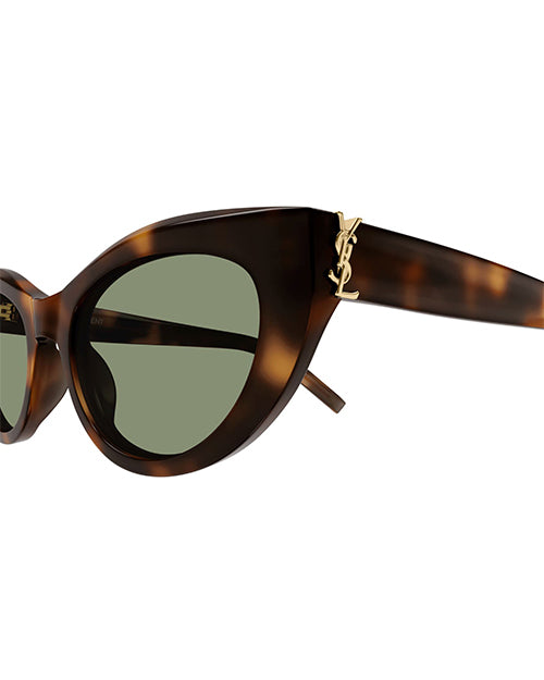 Close up of tortoiseshell sunglasses with a subtle cat-eye shape, and green lenses. There is a small gold-tone metal 'YSL' at the temples.