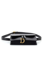  A black clutch purse with a curved flap closure, and a gold-colored clasp, accompanied by a matching black belt with a gold closure.