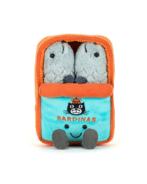 Plush toy shaped like a sardine can with an orange and blue design, featuring the word 'SARDINAS' and a cartoon cat face wearing an orange hat. Two grey sardine plushies with black eyes peek out from the top.