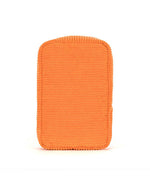 Orange rectangular plush object with rounded corners, ribbed texture, and thicker cord-like edging.