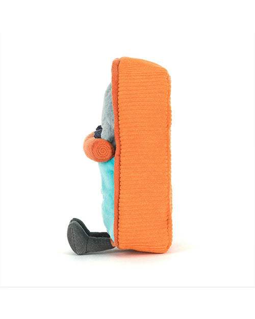 Side view of a plush toy with an orange rectangular textured body, grey head and feet, blue midsection, and rolled-up orange arms.
