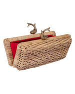 Woven wicker handbag with a red interior lining and two ornate metal clasps shaped like fish.