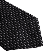 A close-up of a necktie with a black and gray geometric pattern, featuring small, tightly arranged hexagons. 