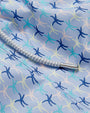 Close-up of a fabric with a pattern of blue, light green, and light pink starfish.