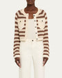 Person wearing a striped cardigan over a white outfit on a plain background