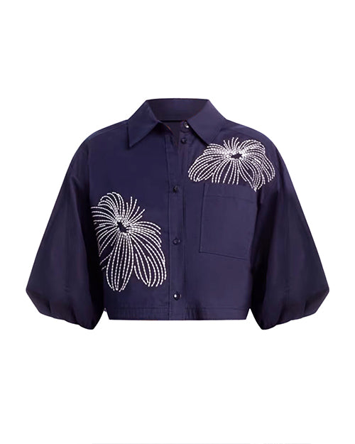 Navy blue shirt with decorative two white floral patterns on a white background