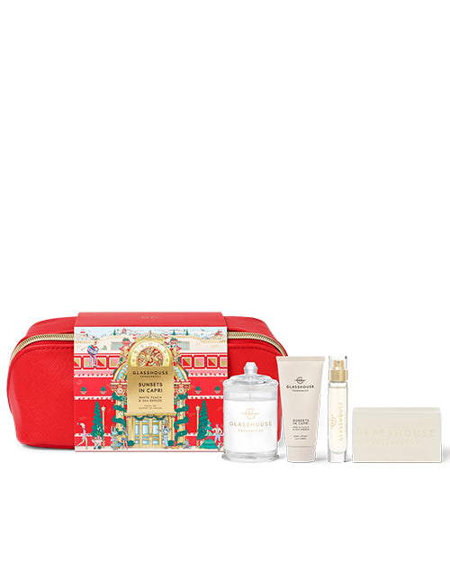 Gift set with a red pouch, candle, lotion, fragrance and a bar of soap on a white background