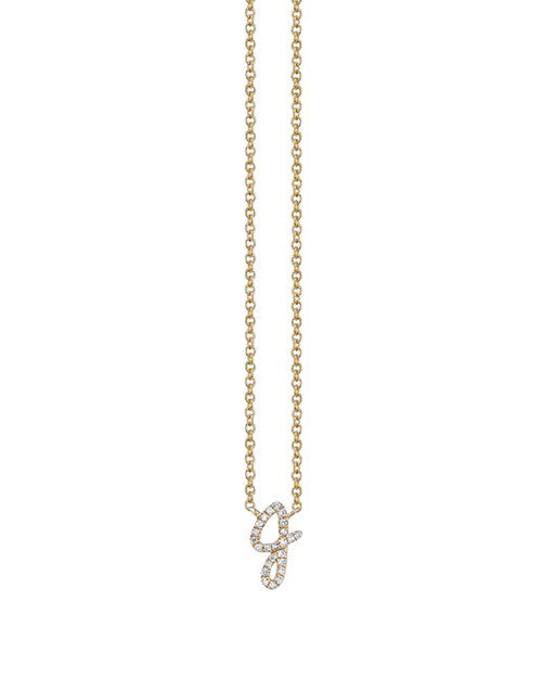 A delicate gold chain necklace with a small pendant with the letter J with pave diamonds.