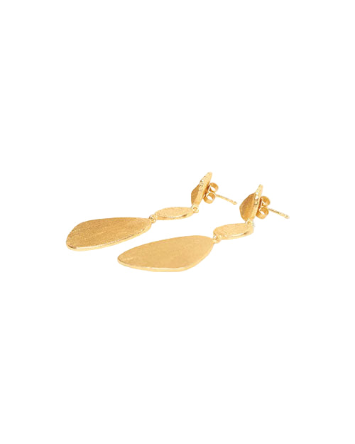 A pair of gold drop earrings with an irregular shape and textured finish, photographed from a slight angle above. Each earring features a stud post with a butterfly back, an oval link, and a larger drop piece.