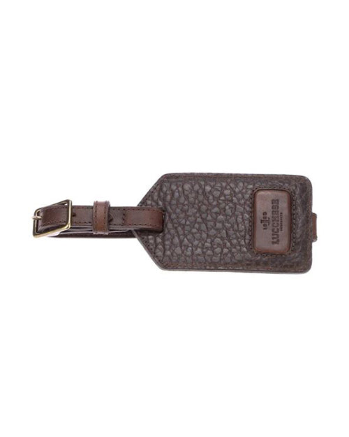 A detailed luggage tag made of textured dark brown leather with a buckle strap and a branded Lucchese label.