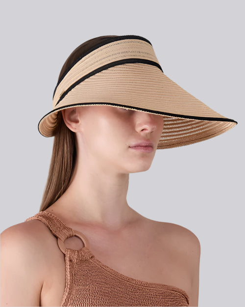 Side view of a person wearing a wide-brimmed straw hat with black trim and a one-shoulder knitted top featuring a ring detail on the strap.