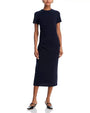 Person wearing a fitted, short-sleeved, dark-colored midi dress with side ruching, paired with pointed-toe ankle-strap flats.