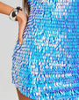 Close up of a feather shaped sequin iridescent blue dress on a person.