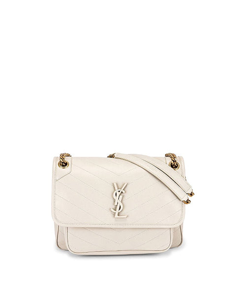A white quilted leather shoulder bag with a gold-toned metal logo resembling the letters ‘YSL’ intertwined on the flap. The bag features a rectangular shape and visible stitching. It has a white chain-link shoulder strap.
