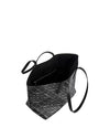Black and white patterned handbag with a single strap. The top portion is solid black, while the bottom features a white geometric design on a black background. The strap is attached to the side.