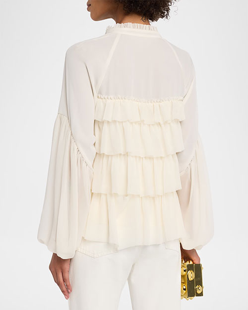 Rear view of a Cream ruffle-front blouse with a split neckline, button detail, and voluminous long sleeves, paired with white pants.