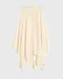 Cream-colored flowing midi skirt with an elastic waistband, soft drape, and asymmetrical handkerchief hem, shown against a light background.
