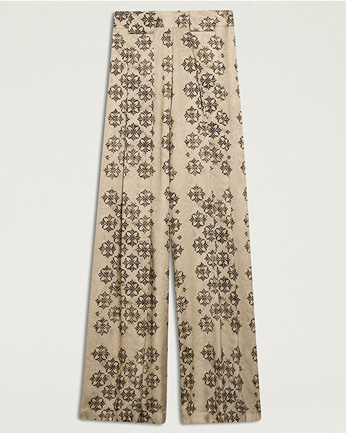 Cream-colored wide-leg trousers featuring an allover black floral-inspired geometric print. The high-waisted trousers have front pleats  and a relaxed, flowing silhouette. 