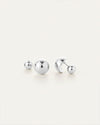 Pair of silver stud earrings featuring polished spherical shapes in two sizes, displayed on a light background.