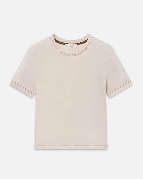 A beige baby tee with brown contrast stitching. 