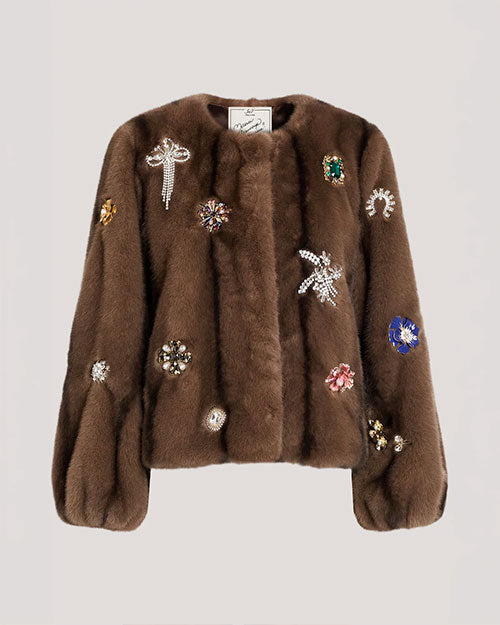 Brown fur-textured jacket embellished with jeweled floral and starburst appliqués, featuring a collarless neckline and voluminous sleeves.