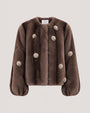 Brown fur-textured jacket with a collarless neckline, voluminous sleeves, and pearl-like floral embellishments throughout.