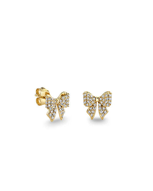 Pair of gold stud earrings shaped like bows, encrusted with small clear gemstones for a sparkling effect. Each bow has two loops and two pointed tails, with a polished gold backing and post.