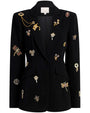 Front view of a black tailored blazer adorned with multiple ornate embroidered and jeweled embellishments, including dragonflies, flowers, and decorative motifs in gold, red, and metallic tones. The blazer features a notched lapel and two front flap pockets.