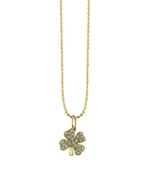 Gold necklace featuring a four-leaf clover pendant adorned with small sparkling stones. Each leaf of the clover is encrusted with stones, and the chain consists of small, round linked beads.