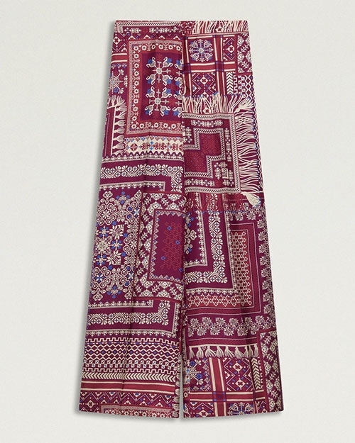 High -waisted, wide-leg trousers featuring an allover patchwork-inspired print in shades of burgundy, pink, cream, and purple.