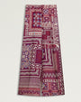 High -waisted, wide-leg trousers featuring an allover patchwork-inspired print in shades of burgundy, pink, cream, and purple.