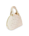 Side view of a small ivory dome-shaped handbag with dual top handles, gold-tone hardware, and decorative pearl studs on the front.