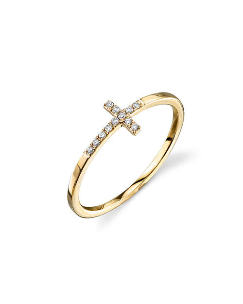 Gold ring featuring a horizontal cross design on the band, adorned with small clear gemstones along the cross. The band is slim and polished for a minimalist look.