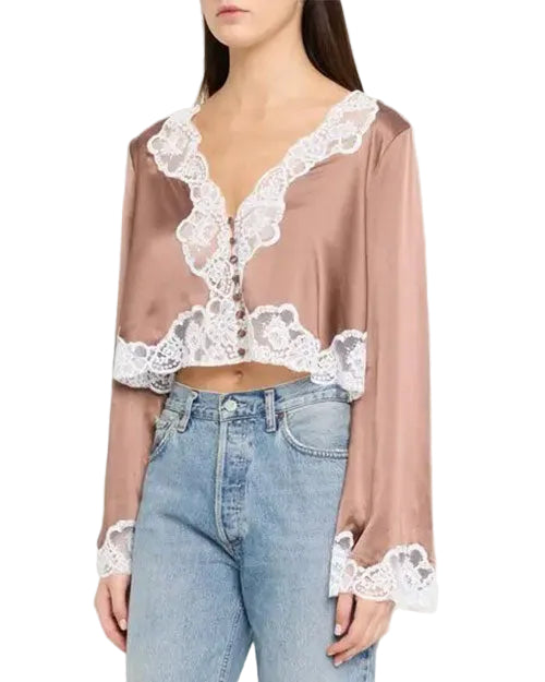 Blush satin cropped blouse with white lace trim, a deep V-neckline, front button closure, long sleeves, and scalloped lace hem, styled with light-wash jeans.