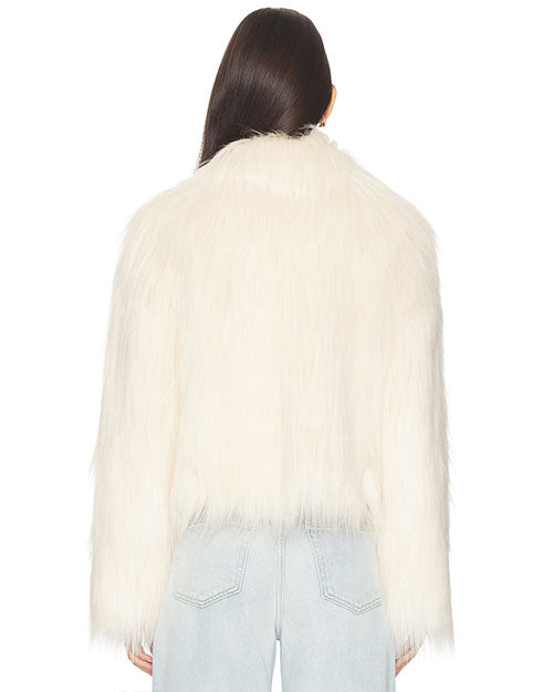 Back view of a person wearing a white faux fur jacket with a long, shaggy texture. The jacket has a slightly cropped length and is paired with light blue denim jeans. The hair is straight and falls down the back, partially covering the collar area of the jacket.