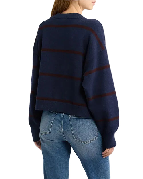 Model wearing a navy blue button-front cardigan with subtle horizontal stripe details and light-wash jeans.