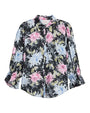 Black button-front blouse with a painterly floral print in pink, white, and green, featuring a pointed collar and three-quarter sleeves with ruffled cuffs.