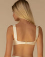 Back view of a woman wearing a cream-colored bikini top with thick shoulder straps. 