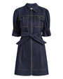 Front view of a dark denim mini dress with a pointed collar, short puff sleeves, front zipper closure, chest flap pockets, contrast topstitching, and a wide self-tie belt at the waist, displayed against a white background.