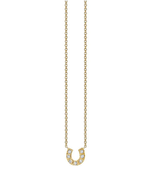 Gold necklace with a delicate chain and a horseshoe-shaped pendant, decorated with small sparkling diamonds along the curve.