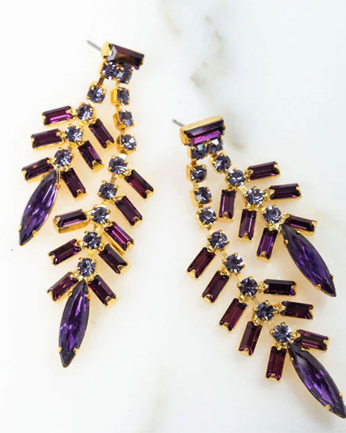 Pair of gold-toned statement earrings featuring cascading branches of purple baguette-cut crystals and marquise-shaped stones, accented with small round clear crystals, arranged in a fan-like design.