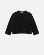 Black cropped jacket with long sleeves and an open front design. The jacket features a textured knit fabric embellished with small pearl-like beads arranged in a scattered pattern.
