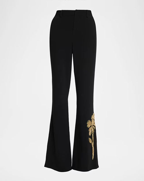 Black flared pants with a gold floral embroidery detail at the lower leg near the hem.